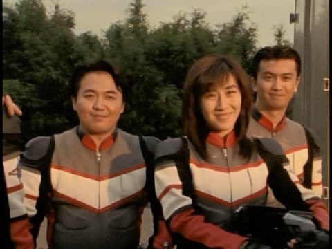 隊長を微笑みながら見つめるユミムラ・リョウ隊員（演：斉藤りさ）